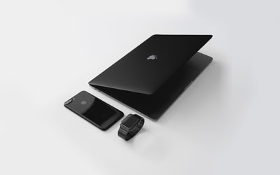 靠近黑色iphone7 Plus和黑色苹果手表的黑色Macbook